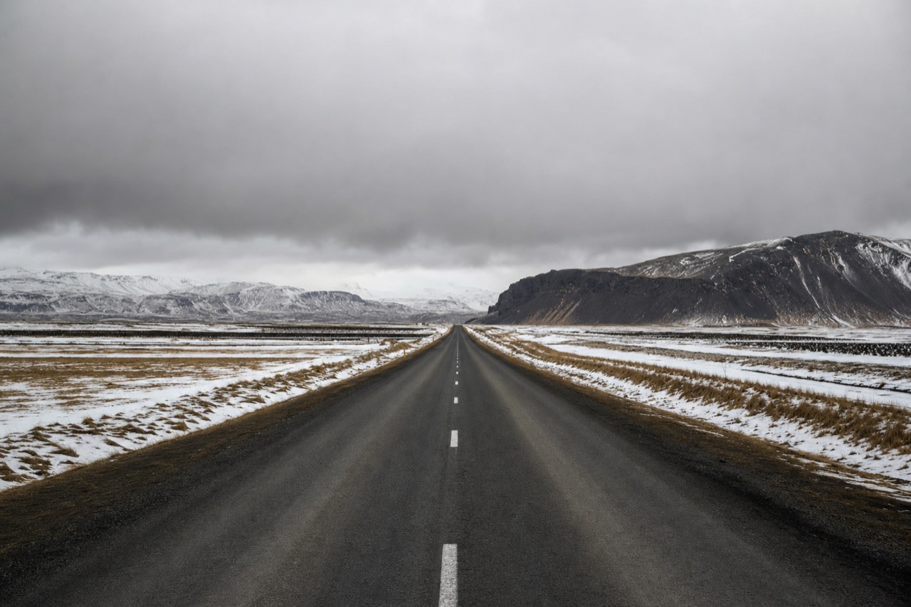 Route 1 running along Iceland's South Coast toward Vik, with mountains inland and open farmland reaching to the sea