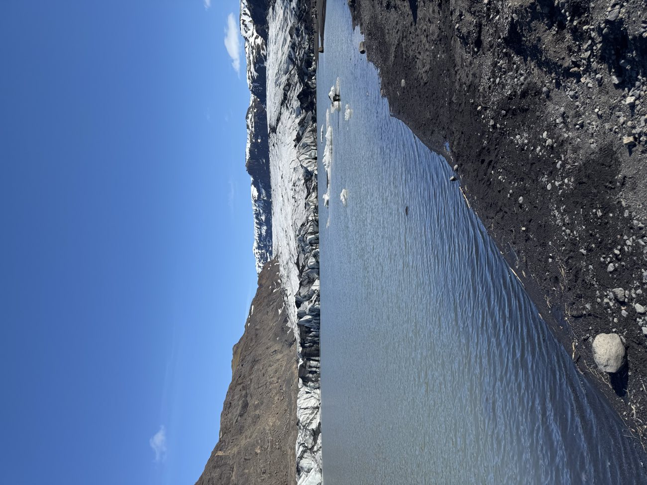 White surf sweeping up the black sand at Reynisfjara, showing how far the waves run up the beach
